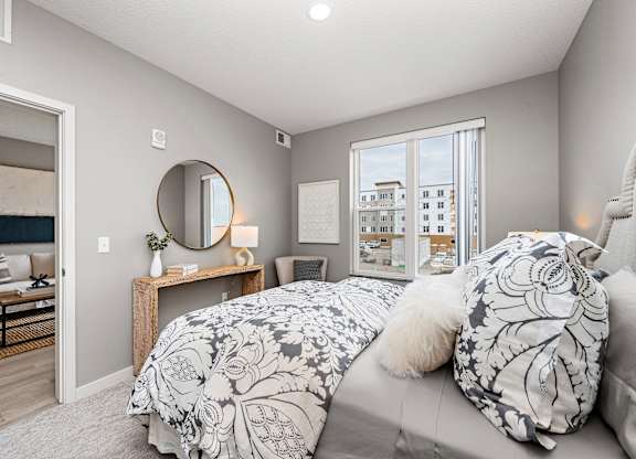 A bedroom with a large bed and a mirror on the wall.