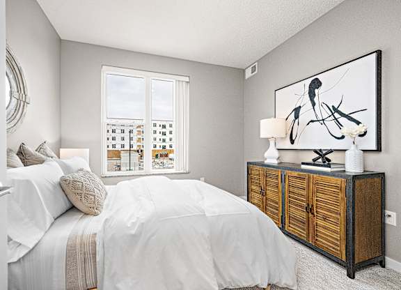 A bedroom with a large bed and a wooden cabinet.