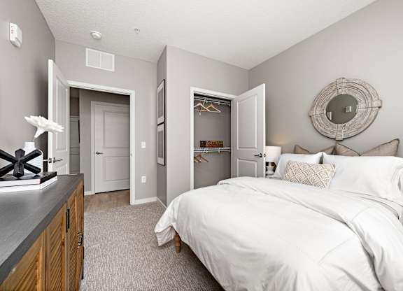 A bedroom with a large bed and a mirror on the wall.