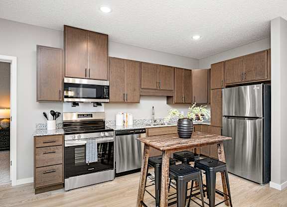 A modern kitchen with wooden cabinets and stainless steel appliances.