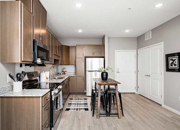 A kitchen with wooden cabinets and a black stove top oven.