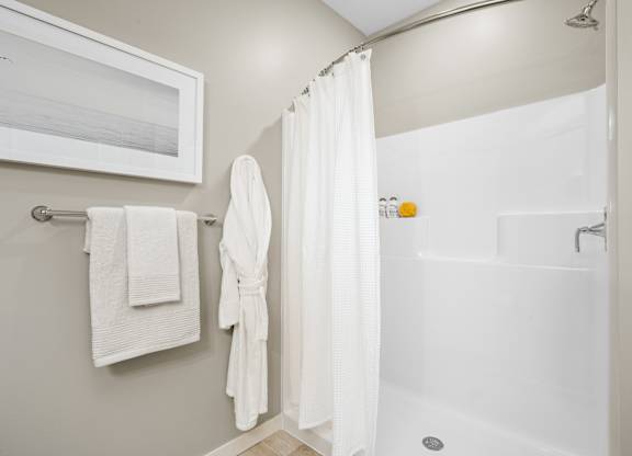 A white bathroom with a white tub and a white shower curtain.
