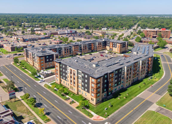 an aerial view of an apartment complex with a large building with a gray roof