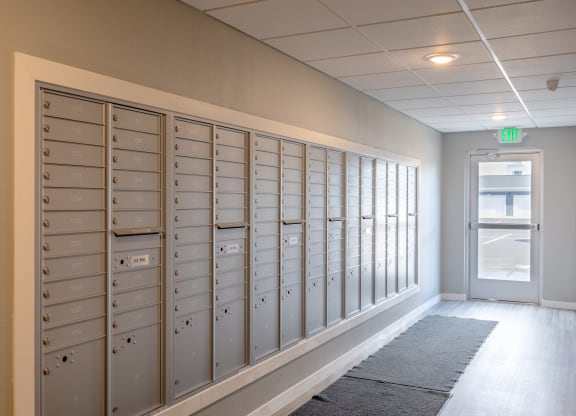 a row of lockers in a hallway with an exit door at Technology Park Apartments, Rochester, Minnesota