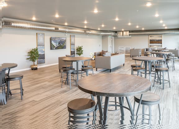 a communal area with tables and chairs in a large room at Technology Park Apartments, Rochester