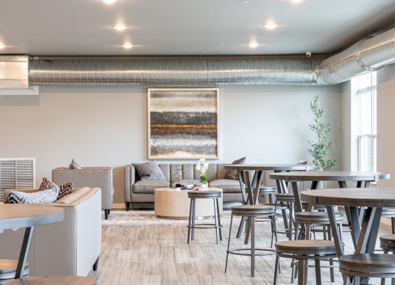 a communal area with tables and chairs in a living room at Technology Park Apartments, Rochester, MN, 55901