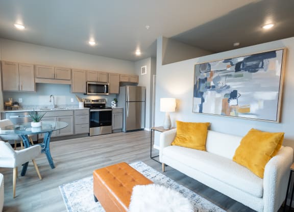 a living room with a couch and a table and a kitchen at Technology Park Apartments, Minnesota