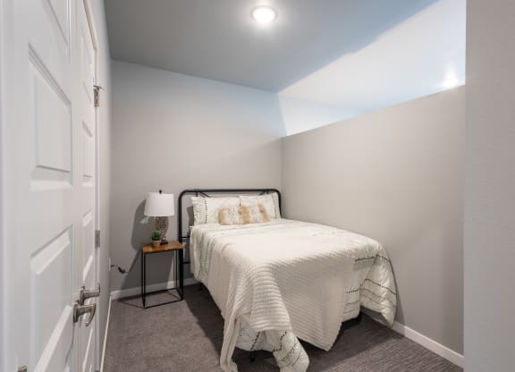 a bedroom with a small bed and a white closet at Technology Park Apartments, Minnesota, 55901
