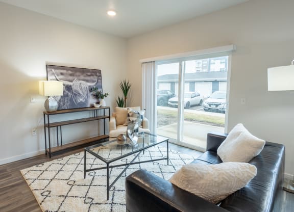 a living room with a black leather couch and a glass coffee table at Technology Park Apartments, Rochester, 55901