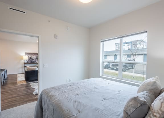 a bedroom with a large bed and a large window at Technology Park Apartments, Minnesota
