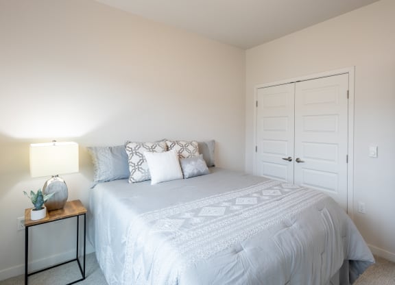 a white bedroom with a white bed and a white closet at Technology Park Apartments, Rochester, 55901