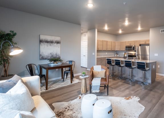 an open living room and kitchen with a dining room table and chairs at Technology Park Apartments, Rochester