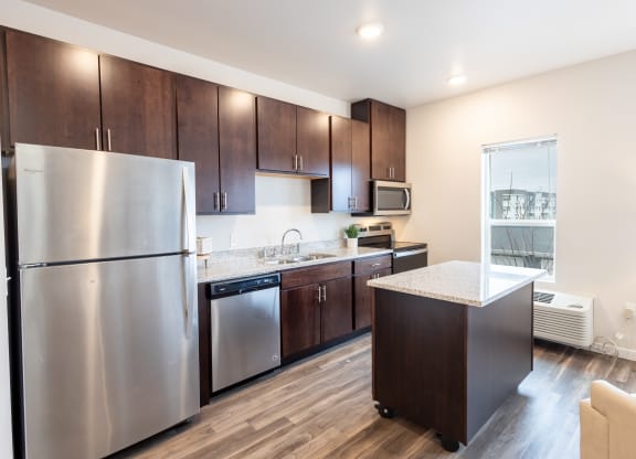 a kitchen with stainless steel appliances and wooden cabinets at Technology Park Apartments, Rochester, MN