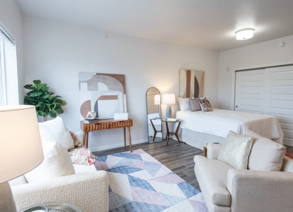 a bedroom with a bed and a living room with a couch and a chair at Technology Park Apartments, Minnesota, 55901