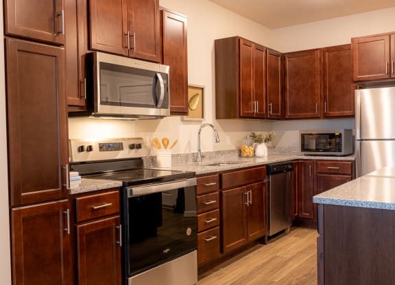 a kitchen with wood cabinets and stainless steel appliances and a counter top