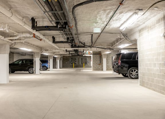 the underground parking garage of a building with parked cars