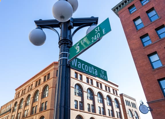 a street light with street signs on it in front of a building