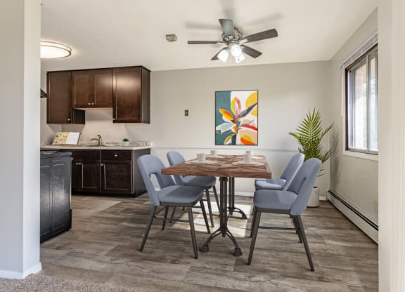 an open kitchen and dining room with a table and chairs and a ceiling fan