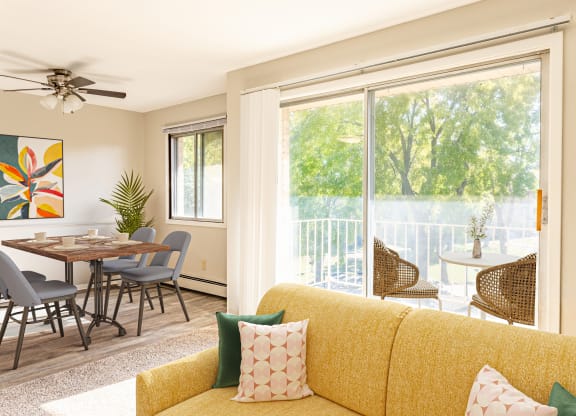 a living room with a yellow couch and a table with chairs