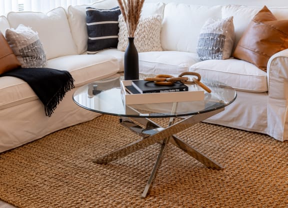 a living room with a white couch and a glass coffee table