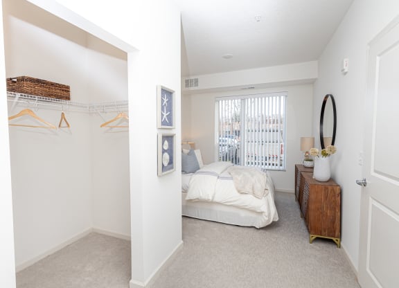a bedroom with a bed and a closet and a window