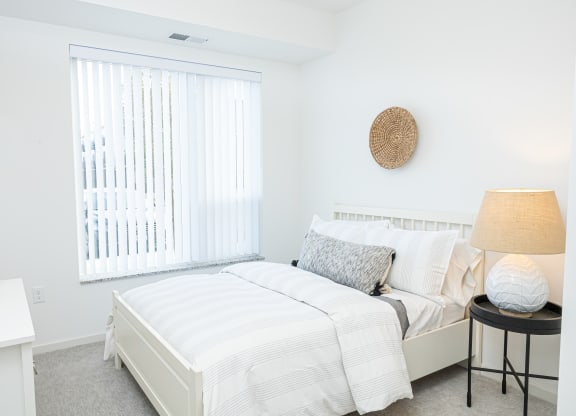 a bedroom with a bed and a large window
