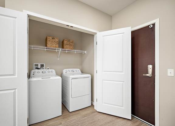 A laundry room with a washer and dryer in it at The Winslow 62+ Apartments, West St Paul, MN
