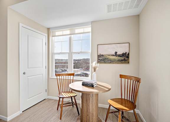 A room with a table and chairs and a painting on the wall at The Winslow 62+ Apartments, West St Paul, MN, 55118