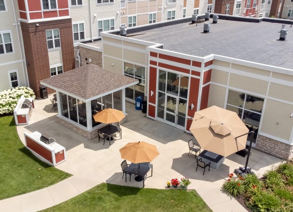 an aerial view of the courtyard of a building with tables and umbrellas at The Winslow 62+ Apartments, West St Paul, MN, 55118