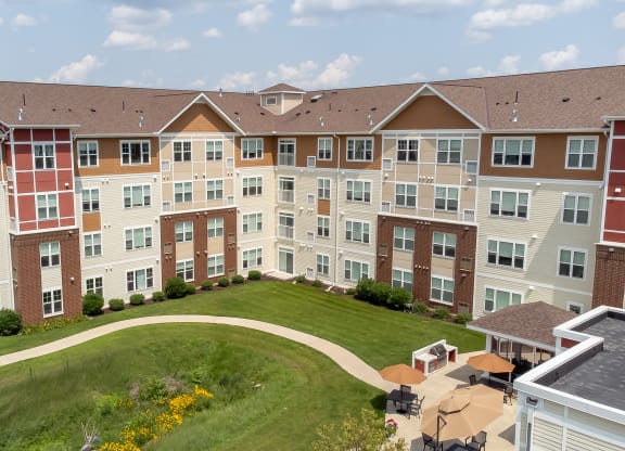 an aerial view of an apartment building on a green lawn at The Winslow 62+ Apartments, West St Paul