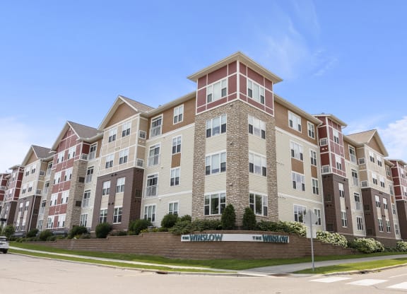 an apartment building on the corner of a street at The Winslow 62+ Apartments, West St Paul, MN