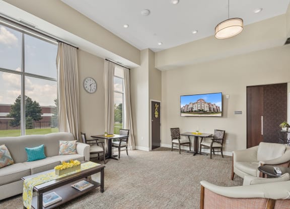 a living room with a couch and a table with chairs at The Winslow 62+ Apartments, West St Paul, 55118