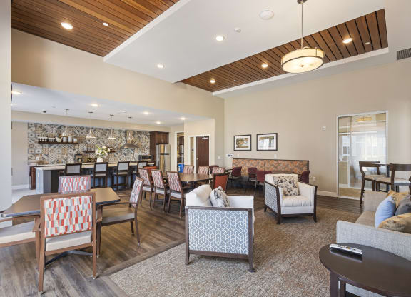 a living room with couches and chairs and a dining room with tables and chairs at The Winslow 62+ Apartments, Minnesota, 55118