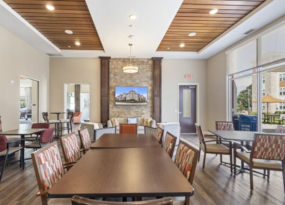 a dining room with a table and chairs and a fireplace at The Winslow 62+ Apartments, West St Paul, MN, 55118