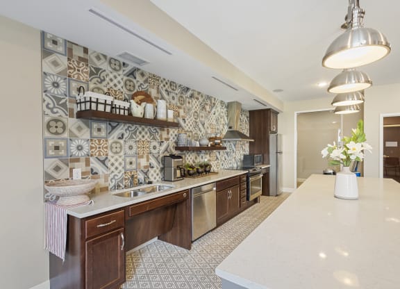 a kitchen with tiles on the wall and a white counter top at The Winslow 62+ Apartments, West St Paul, Minnesota