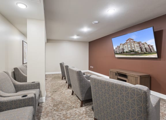 a community room with couches and chairs and a tv on the wall at The Winslow 62+ Apartments, Minnesota