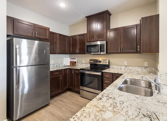 a kitchen with stainless steel appliances and marble counter tops at The Winslow 62+ Apartments, West St Paul