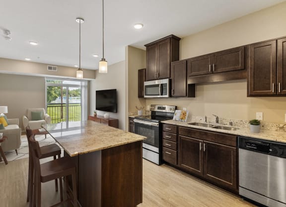 an open kitchen and living room with a table and chairs at The Winslow 62+ Apartments, West St Paul, Minnesota