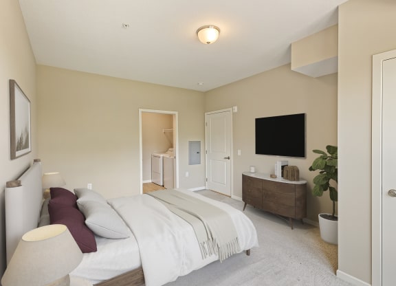 a bedroom with a bed and a dresser and a tv at The Winslow 62+ Apartments, West St Paul, MN