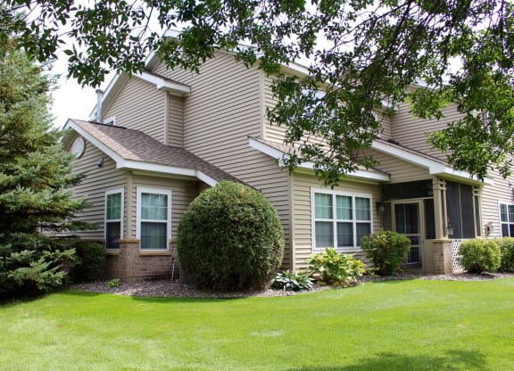 exterior of townhome with screened in porch and landscaping