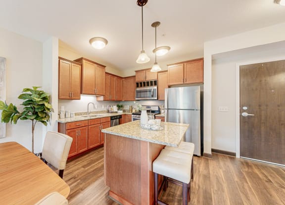 a kitchen with wooden cabinets and a table with chairs