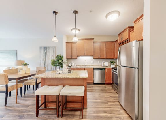 a kitchen and dining room with stainless steel appliances and wooden cabinets