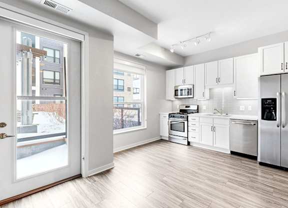 A modern kitchen with stainless steel appliances and white cabinetry.
