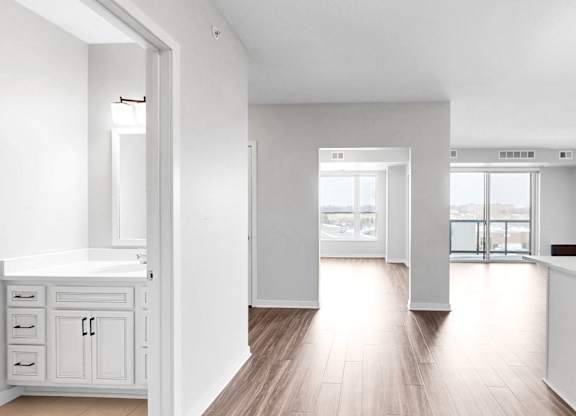 A white kitchen with a large island and a view of the city.