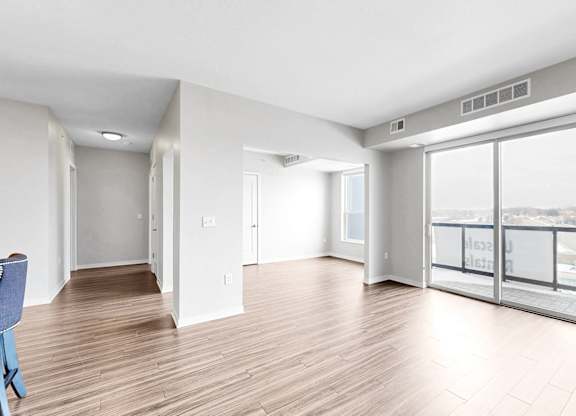 A room with a blue chair and wooden flooring.