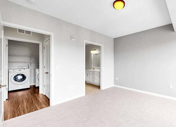 A laundry room with a washer and dryer is visible from the open door.