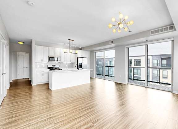 A spacious kitchen with wooden floors and a large island.