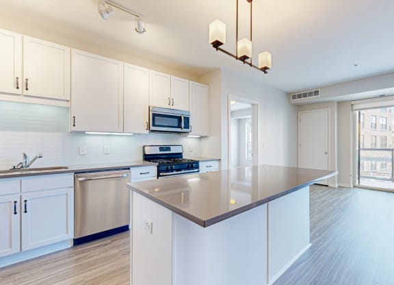 a large kitchen with white cabinets and a counter top