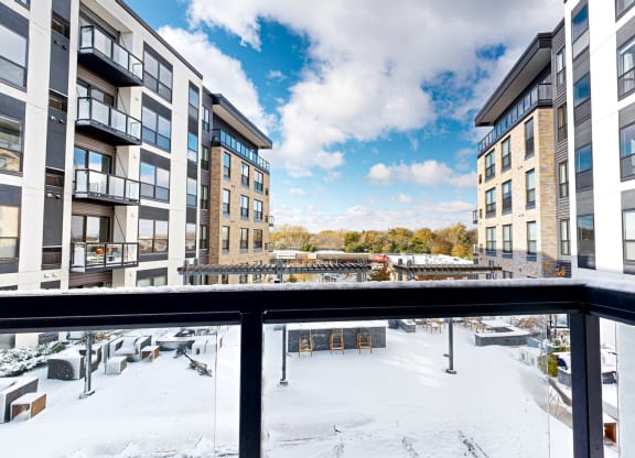 the view from the balcony of an apartment building in the snow