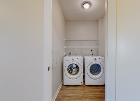 a designated laundry room with side by side washer and dryer and built in wire shelving